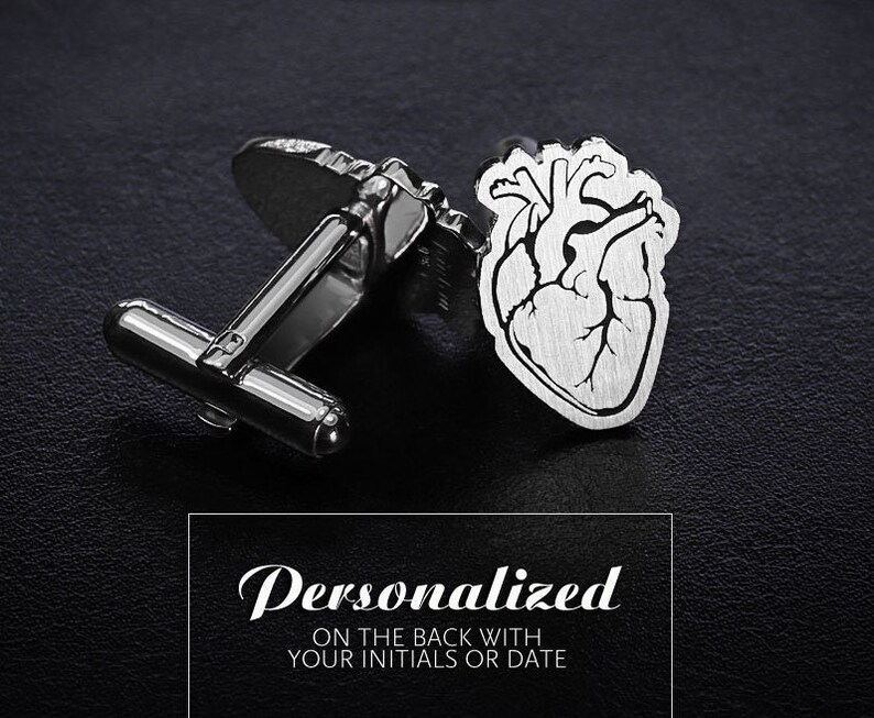 May include: Silver cufflinks with a heart design. The heart is detailed with lines and a textured finish. The cufflinks are personalized with your initials or date on the back.