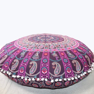 K&ouml;nnte beinhalten: Runder Bodenkissen mit Mandala-Design in Lila, Pink und T&uuml;rkis. Das Kissen hat ein detailliertes Muster mit Paisley- und T&auml;nzerfiguren. Wei&szlig;e Pompons s&auml;umen den Rand. Der Durchmesser betr&auml;gt ca. 90 cm.