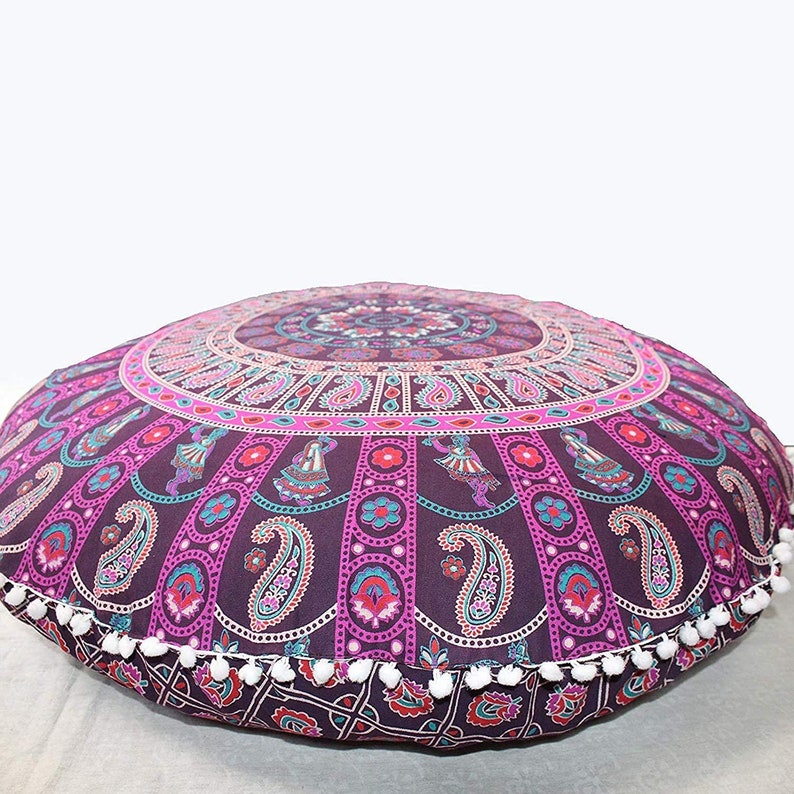 K&ouml;nnte beinhalten: Runder Bodenkissen mit Mandala-Design in Lila, Pink und T&uuml;rkis. Das Kissen hat ein detailliertes Muster mit Paisley- und T&auml;nzerfiguren. Wei&szlig;e Pompons s&auml;umen den Rand. Der Durchmesser betr&auml;gt ca. 90 cm.