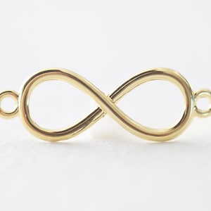 Könnte beinhalten: Goldener Unendlichkeits-Anhänger mit zwei Sprungringen zum Anbringen an Schmuck oder andere Bastelarbeiten.