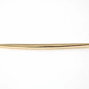 Könnte beinhalten: Ein goldfarbener Häkelhaken mit einer spitzen Spitze und einer kleinen Schlaufe am Ende.