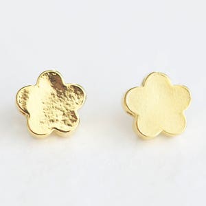 May include: A pair of gold flower-shaped stud earrings.