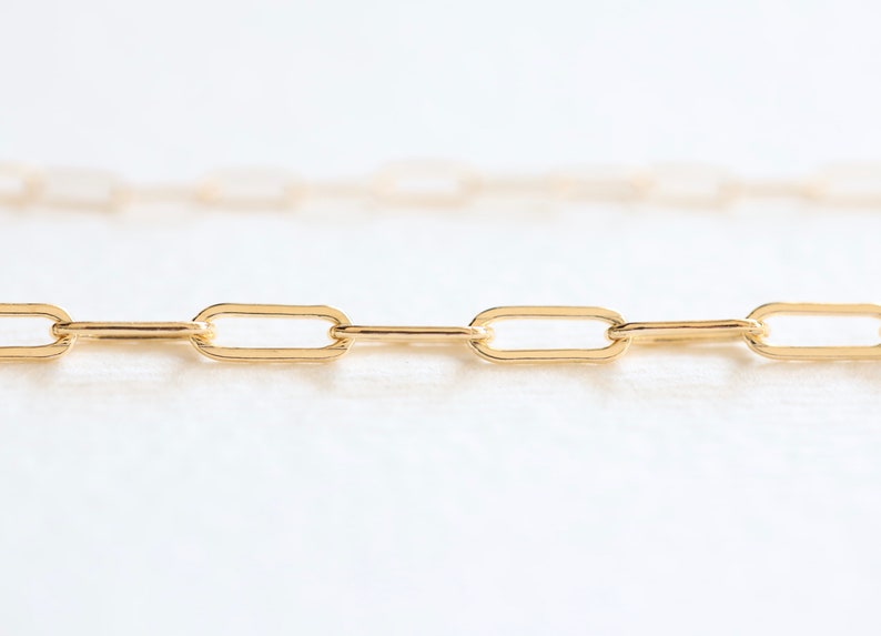 May include: A gold chain necklace with a delicate, oval-shaped link design.