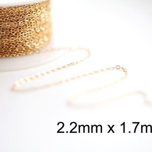 May include: A spool of gold-colored chain with a delicate, oval link design. The chain is partially unraveled, displaying its fine construction. The text "2.2mm x 1.7mm" is visible, indicating the chain's dimensions.