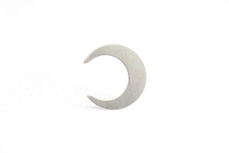 May include: A silver crescent moon shaped earring.
