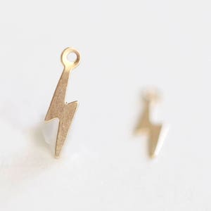 May include: Two gold-toned lightning bolt charms with a jump ring for attaching to jewellery.