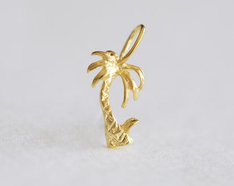 May include: A gold palm tree charm pendant. The palm tree is detailed with textured leaves and a trunk.