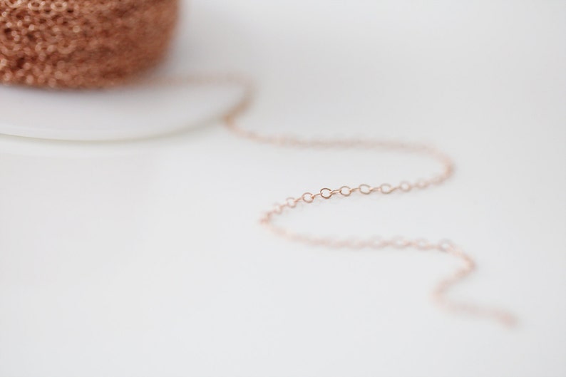 Op de afbeelding: Een close-up van een ros&eacute;gouden kettingketting. De ketting is gemaakt van kleine, delicate schakels.