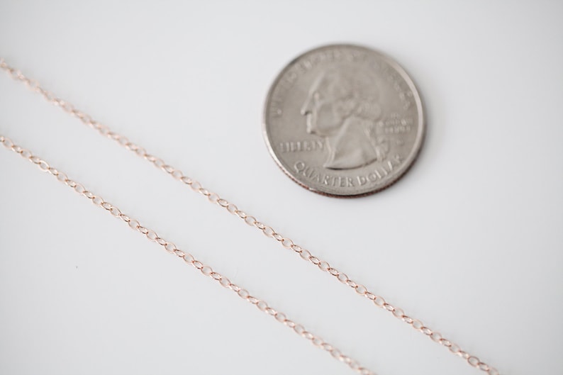 Op de afbeelding: Een ketting van ros&eacute;goud, getoond naast een Amerikaanse kwart dollar voor schaal.