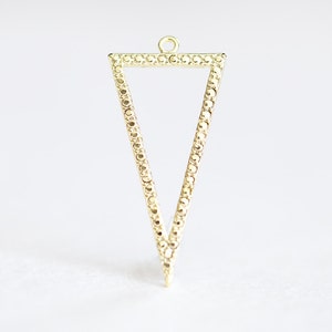 May include: A gold triangle pendant with a textured border. The pendant has a loop at the top for attaching a chain.