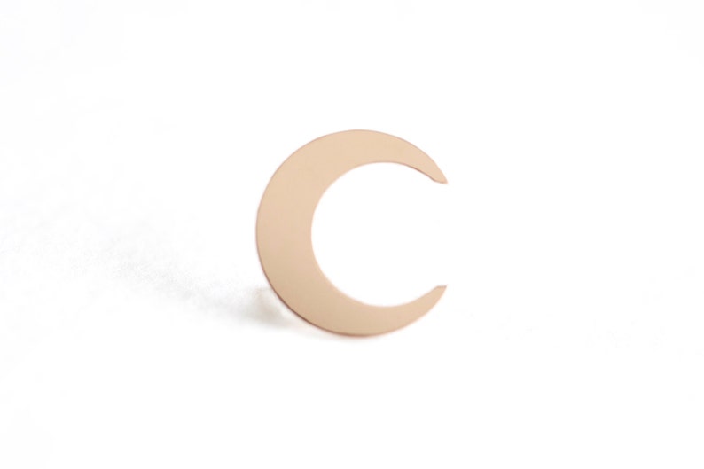 May include: A gold crescent moon charm pendant.