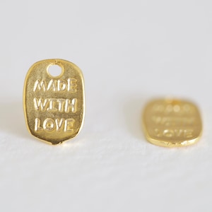 May include: Two gold-colored metal tags with the words "Made with Love" embossed on them.