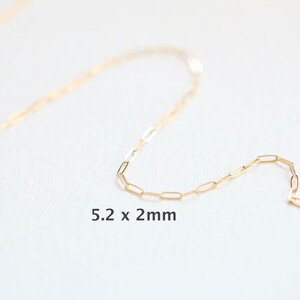 May include: A gold chain necklace with a delicate, rectangular link design. The chain is 5.2 x 2 mm in size.