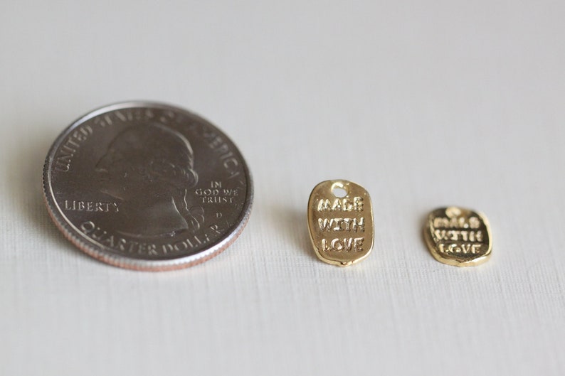 May include: Two gold-colored metal tags with the text "Made with Love" on them. The tags are about the size of a US quarter.