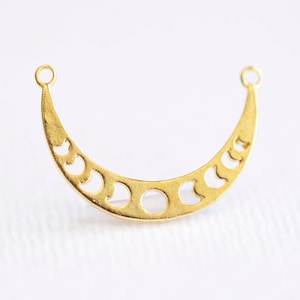 May include: Gold-toned metal crescent moon charm with cut-out moon phases. The charm has two jump rings for attaching to jewelry.