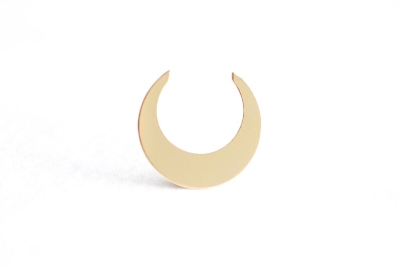 May include: A gold crescent moon shaped earring.
