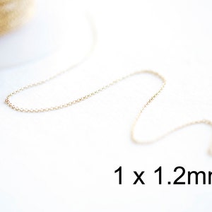 Puede incluir: Primer plano de una cadena de oro de 1 x 1,2 mm sobre un fondo blanco.