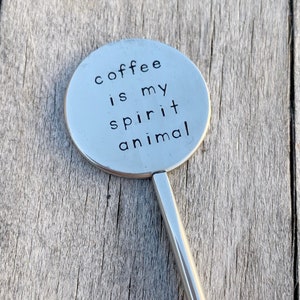 May include: A silver metal stirring spoon with a round, flat end that says "coffee is my spirit animal".