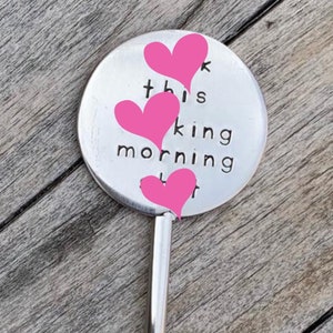 May include: A silver metal disc with the text "This is my kind of morning" and three pink hearts. The disc is attached to a silver metal stem.