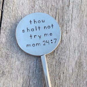 May include: A silver metal keychain with a round tag that says "Thou shalt not try me mom 24:7".