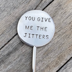 May include: A silver metal garden stake with a round top that says "You give me the jitters".