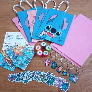 May include: A collection of Stitch-themed party supplies, including blue and pink gift bags, stickers, stamps, keychains, and notepads. The gift bags feature Stitch's face. A sheet of paper reads "Thanks for coming!"