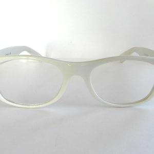 Puede incluir: Gafas de plástico blanco con lentes transparentes.