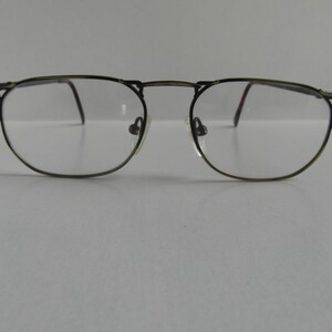 Puede incluir: Un par de gafas de metal dorado con lentes transparentes.