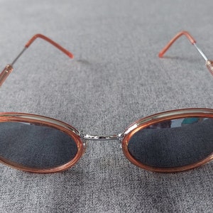 Occhiali da sole vintage con montatura ovale color argento e pesca traslucida
