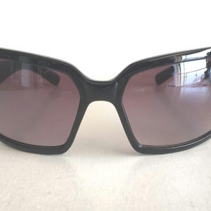 May include: Black sunglasses with a square frame and dark lenses.