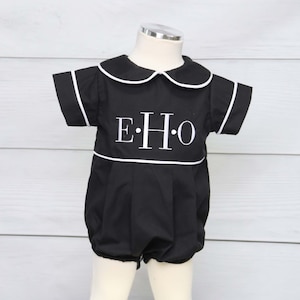 May include: Black baby romper with white trim and a Peter Pan collar. The romper features the embroidered letters "EHO" in white. The short-sleeved outfit has a bubble bottom and is displayed on a mannequin.