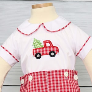 Puede incluir: Conjunto de camisa blanca y pantal&oacute;n corto a cuadros rojos. La camisa presenta un cami&oacute;n rojo con un &aacute;rbol de Navidad verde. El cuello y las mangas est&aacute;n ribeteados con cuadros rojos. El pantal&oacute;n corto tiene botones blancos.