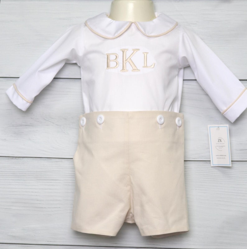 Toddler boy clothes is a 2 piece bobby suit in light khaki with white shirt.  Shirt is trimmed in khaki piping.  Available with or without monogram.