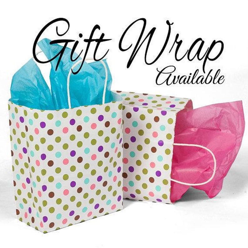 K&ouml;nnte beinhalten: Zwei Geschenkt&uuml;ten mit Tupfenmuster. Eine T&uuml;te ist wei&szlig; mit gr&uuml;nen, braunen, rosa und violetten Punkten. Die andere T&uuml;te ist wei&szlig; mit gr&uuml;nen, braunen und violetten Punkten. Beide T&uuml;ten haben blaues und rosa Seidenpapier drin. Der Text "Gift Wrap Available" ist in Schwarz &uuml;ber den T&uuml;ten geschrieben.