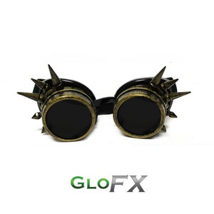 Könnte beinhalten: Eine schwarze Steampunk-Brille mit goldenen Akzenten und Spikes. Die Brille hat runde Gläser und einen schwarzen Rahmen.