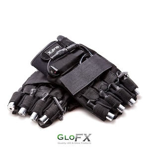 Puede incluir: Guantes de luz LED negros con luces plateadas en los dedos. Los guantes tienen una correa de velcro y una batería. La marca "GLO FX" está impresa en los guantes.