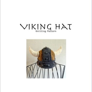 May include: A knitted Viking hat with horns, brown and gray in color. The hat is on a black stand. The text "VIKING HAT Knitting Pattern" is at the top of the image.