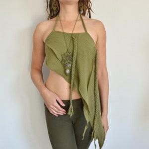 May include: An olive green halter top made of textured fabric with an asymmetrical hemline and braided strap details. The top is paired with a macrame pendant necklace featuring a tree design and two oval-shaped stones, along with matching spiral earrings.
