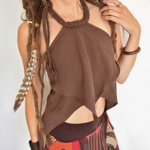 Può includere: Un top marrone con scollo a halter e un design asimmetrico a strati con un intreccio sul collo. Il top è realizzato in un tessuto morbido e leggero e ha una vestibilità rilassata.