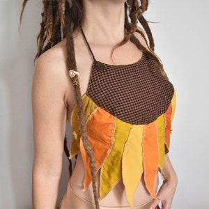 Peut inclure: Un haut halter brun et orange avec un motif g&eacute;om&eacute;trique. Le haut est fait de diff&eacute;rents tissus et a un design unique et asym&eacute;trique.