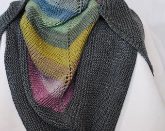 Puede incluir: Un chal de punto gris con una sección de rayas de colores en tonos de rosa, morado, amarillo, verde y azul.