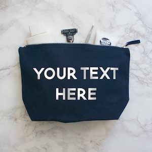 May include: A dark blue canvas zippered pouch with the text "YOUR TEXT HERE" printed in silver on the front.