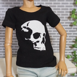 May include: Black t-shirt with a white skull graphic. The skull is stylized and has a detailed design.