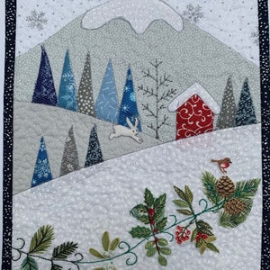 May include: A wintery scene with a red house, a white rabbit hopping through a snowy forest, and a robin perched on a branch with holly and pine cones. The background is a white snowy landscape with a grey mountain in the distance.