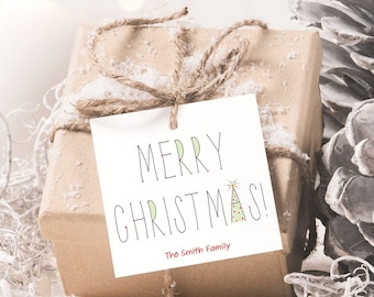 May include: A brown gift box with a white gift tag that says "Merry Christmas!" with a green and yellow party hat illustration. The tag also says "The Smith Family" in red text. The gift box is surrounded by white candles and white snow.