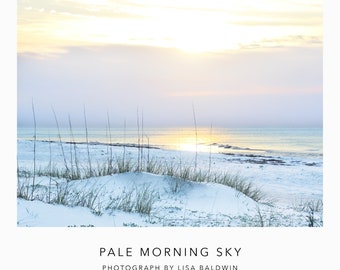 Foto de la playa del amanecer: un cielo matutino pálido con el sol saliendo sobre las dunas de arena blanca como el azúcar junto a un océano acuático