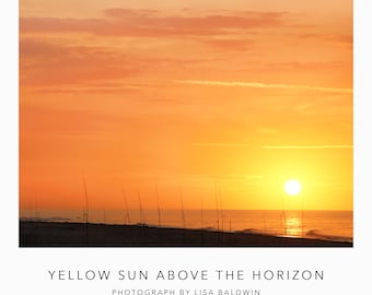 Foto dorada profunda del amanecer con el sol justo encima del horizonte reflejado en el agua del océano - Amanecer en la playa