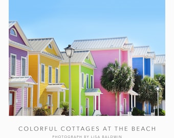 Foto de cabañas coloridas junto al océano: casas de playa de color púrpura brillante, amarillo, rosa lima y azul en una fila