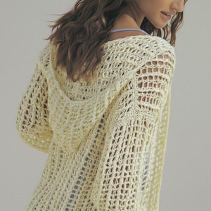 May include: A light yellow, open-weave hooded sweater. The sweater has long sleeves and a hood. The knit pattern creates a mesh-like appearance. The garment is made of a soft, lightweight material, perfect for layering.