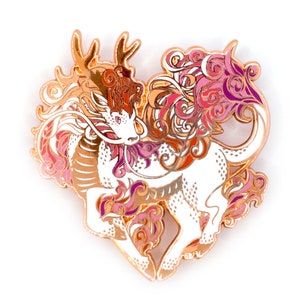 May include: A gold-tone enamel pin featuring a stylized dragon with pink, orange, and purple swirls. The dragon is in a heart shape.